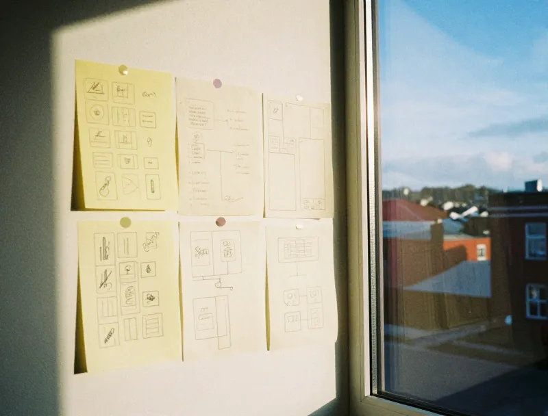 Pencil sketches of app flows pinned to a studio wall