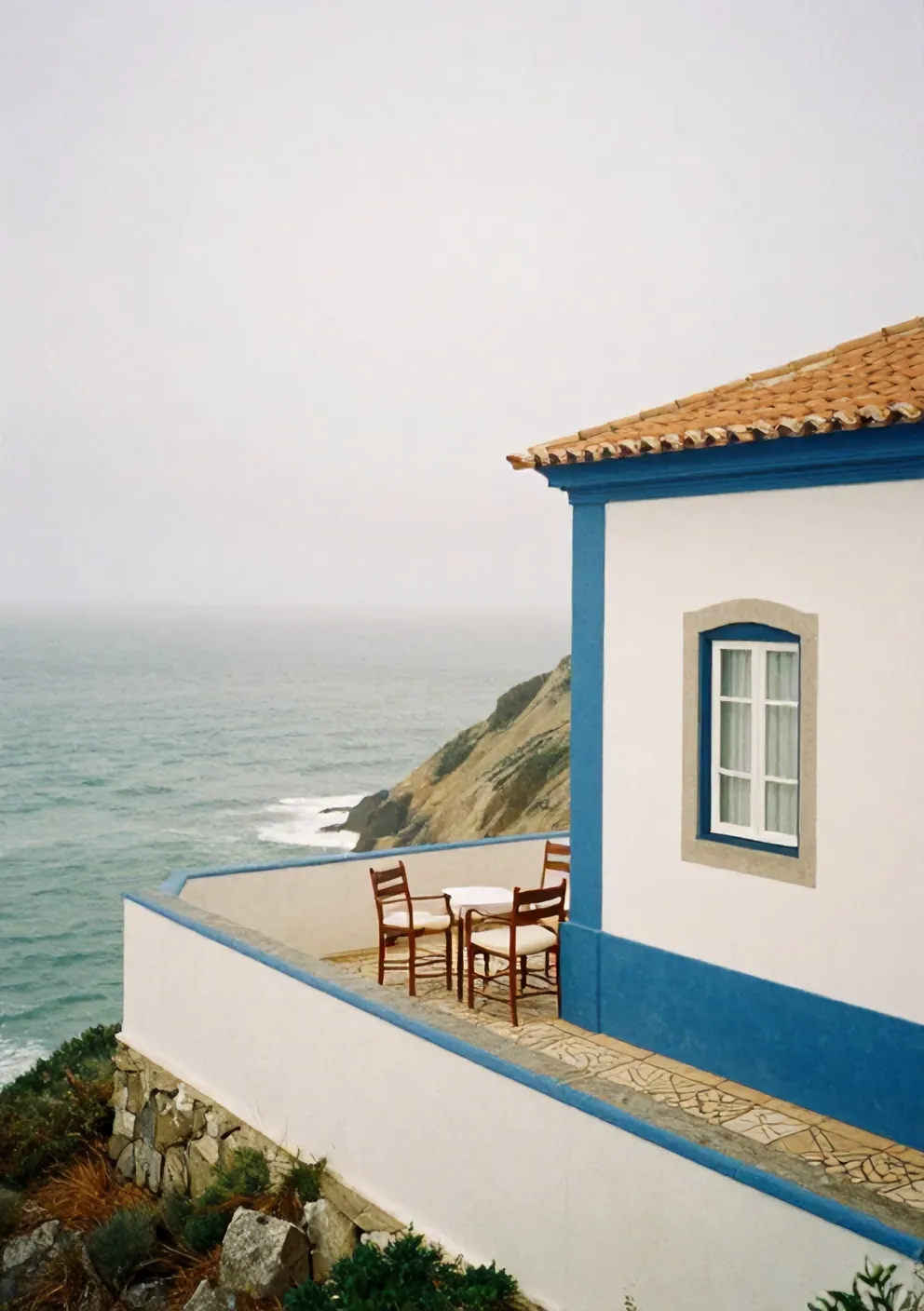 Casa Mirante's whitewashed façade with blue trim on the cliff above Ericeira