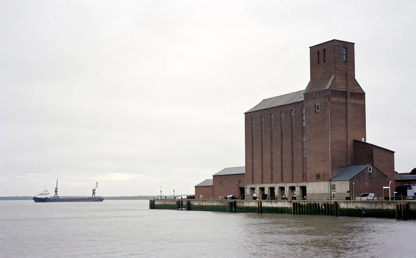Maassilo, the 1910 brick and concrete grain silo, seen across the grey water of Maashaven in Rotterdam-Zuid