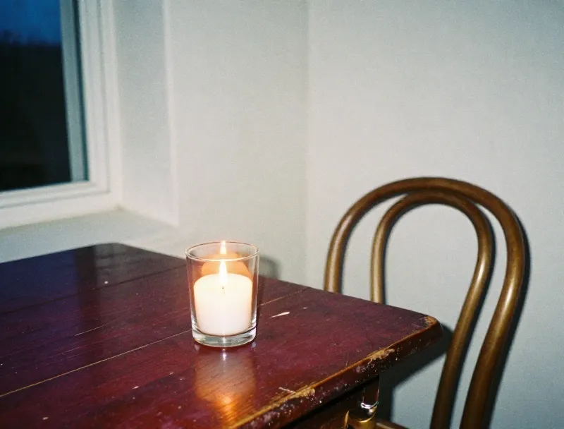 A candle in glass on a wooden table