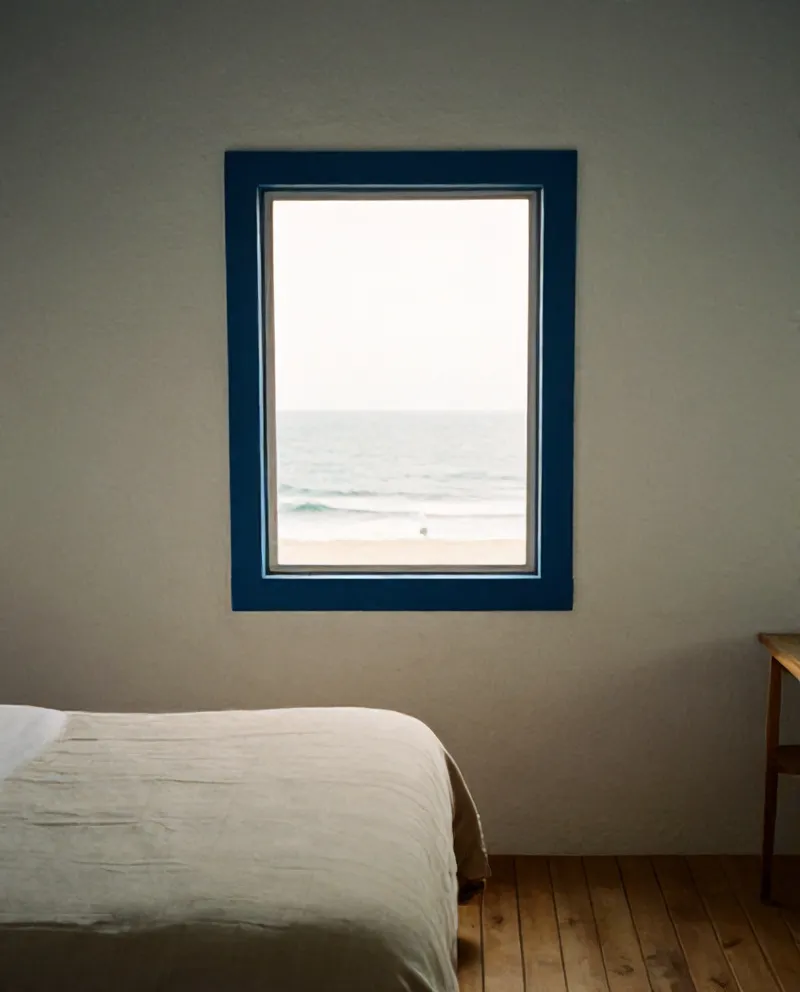 A whitewashed bedroom with a window onto the Atlantic