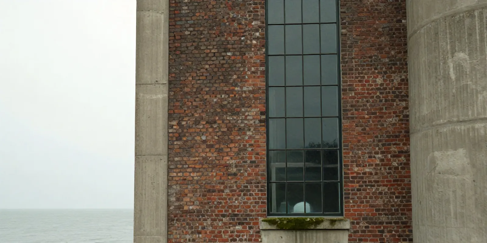 Brick and concrete wall of the Maassilo with a tall industrial window