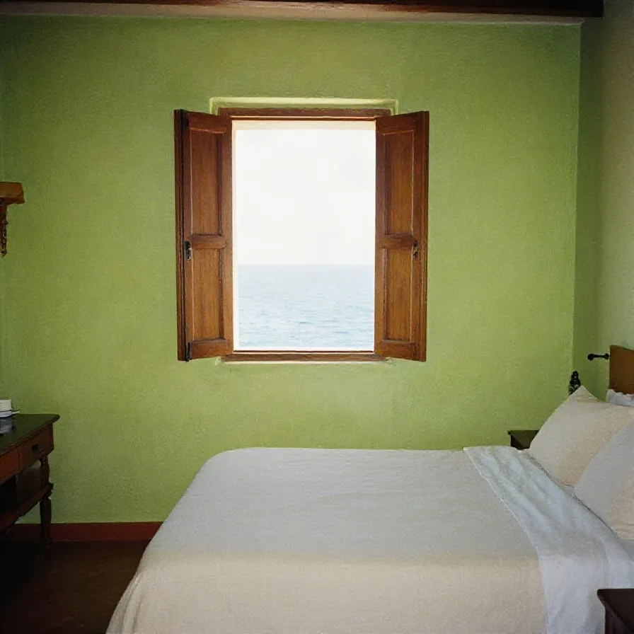 A bedroom with shutters open to the sea