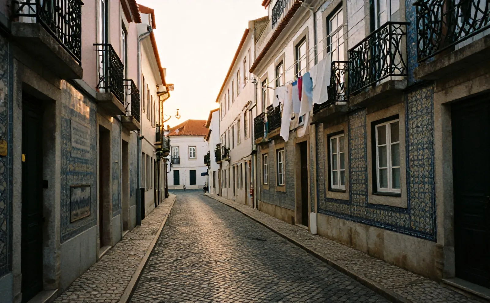 Rua dos Remédios in Alfama in the last evening light, cobbles, balconies and washing lines