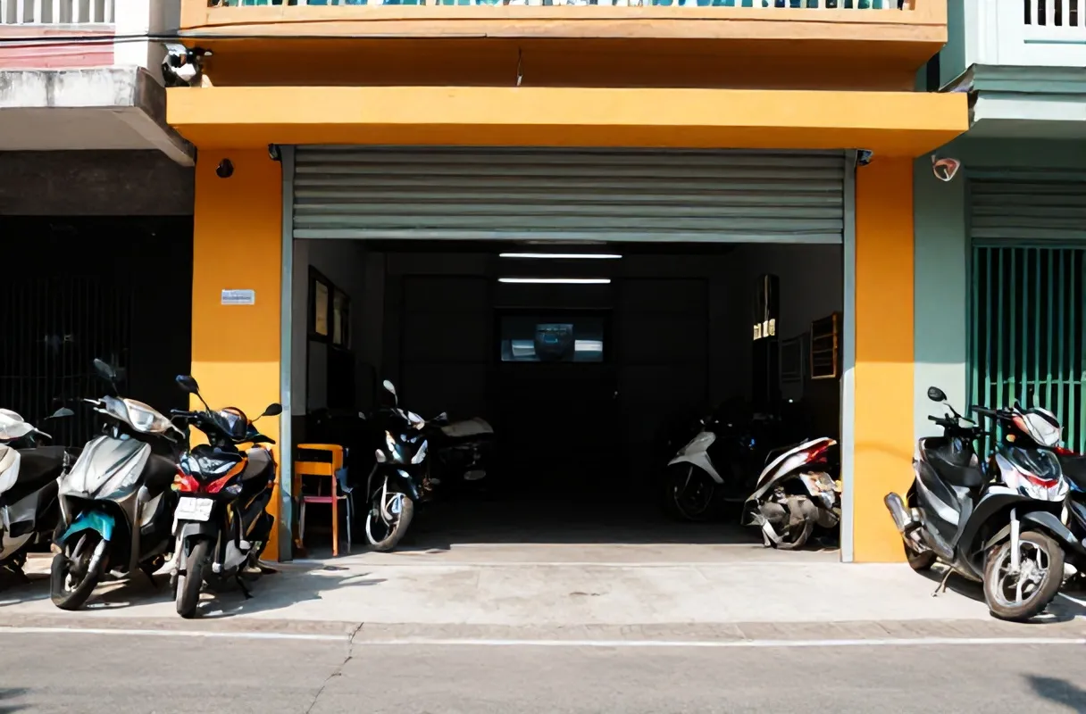 Bengkel Jaya Abadi dengan pintu rolling dibuka dan motor warga terparkir di depan