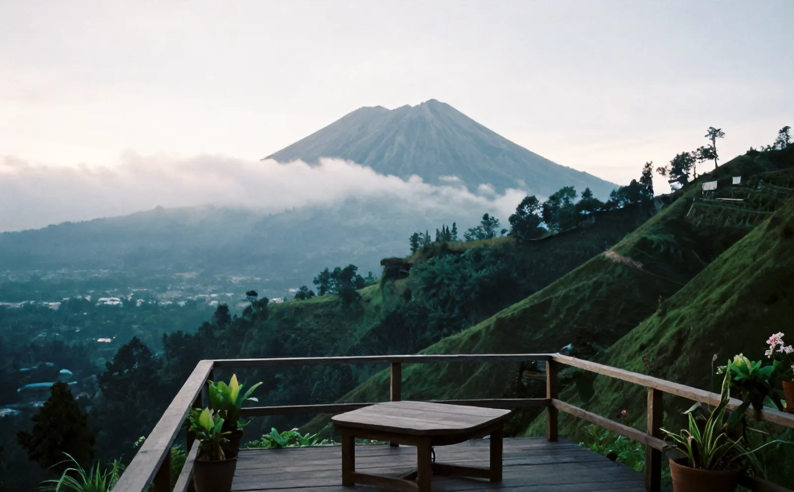 Gunung Merapi berselimut kabut pagi, dilihat dari teras kayu Kopi Lereng di Kaliurang