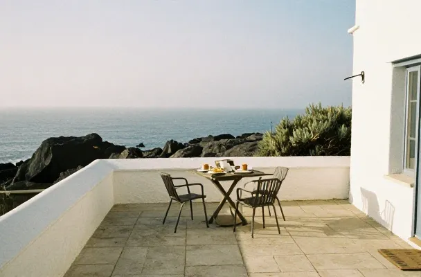 The terrace table set for breakfast, facing the ocean