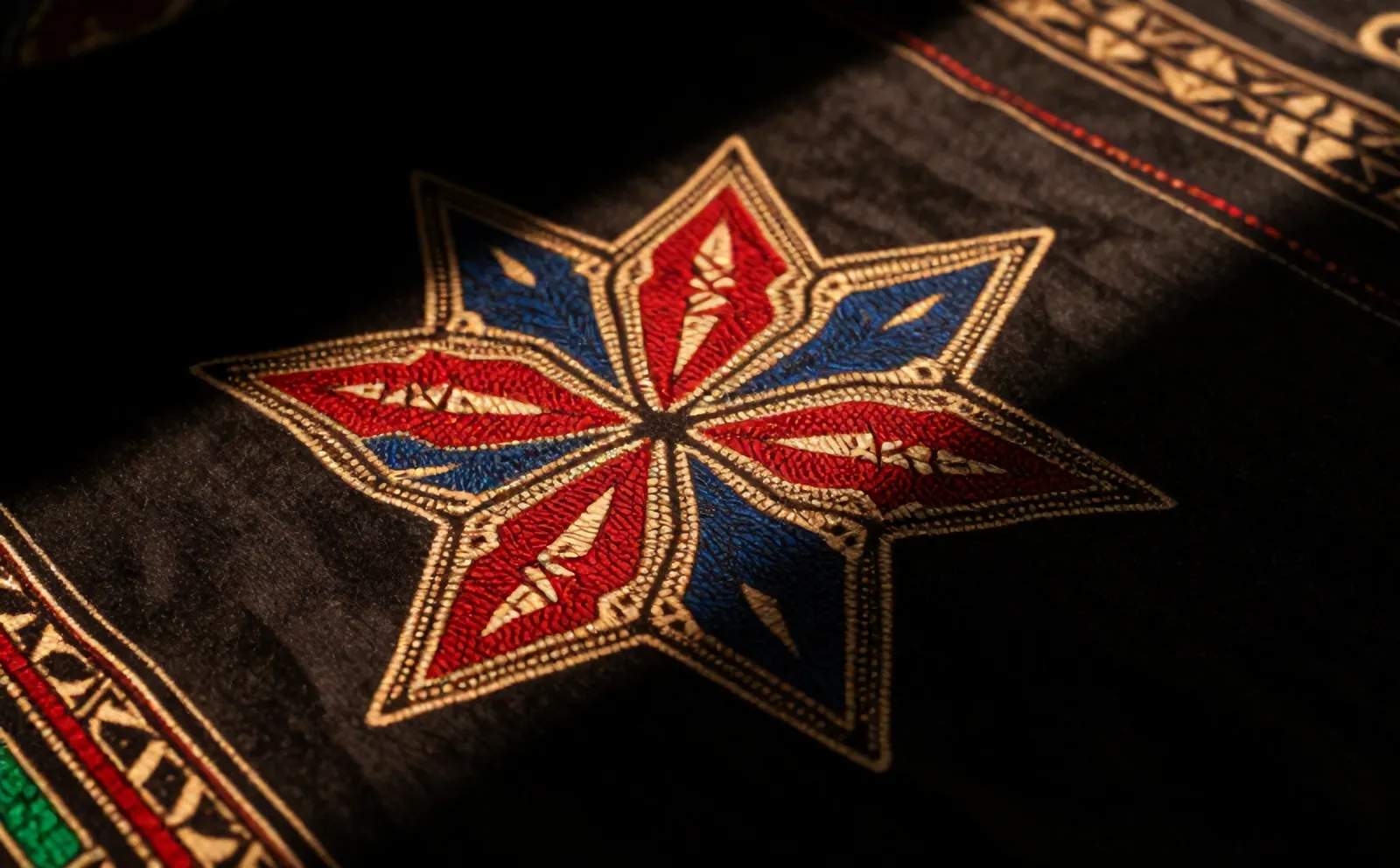 Detail kain batik Jlamprang dengan bintang bersudut delapan merah, indigo, dan krem