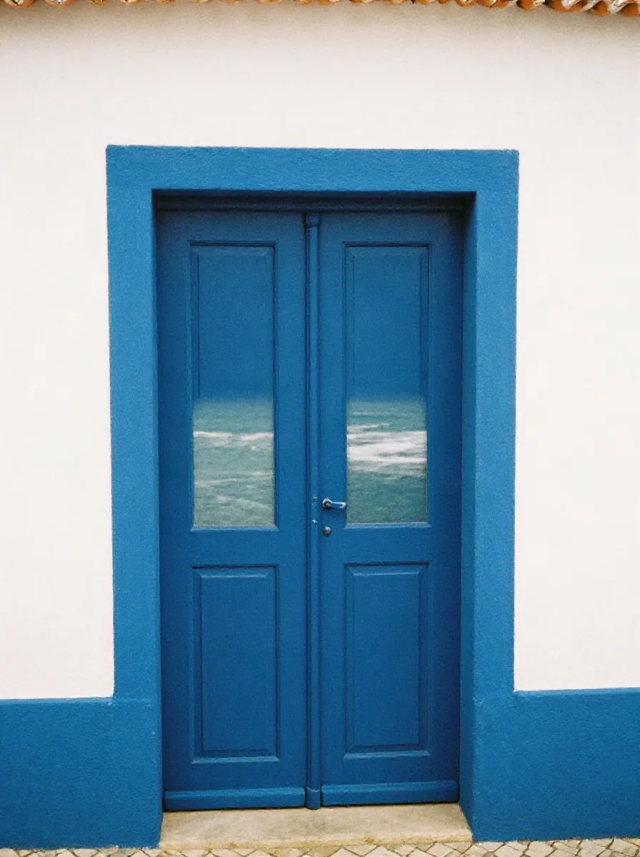 Blue-trimmed door of a whitewashed house in Ericeira