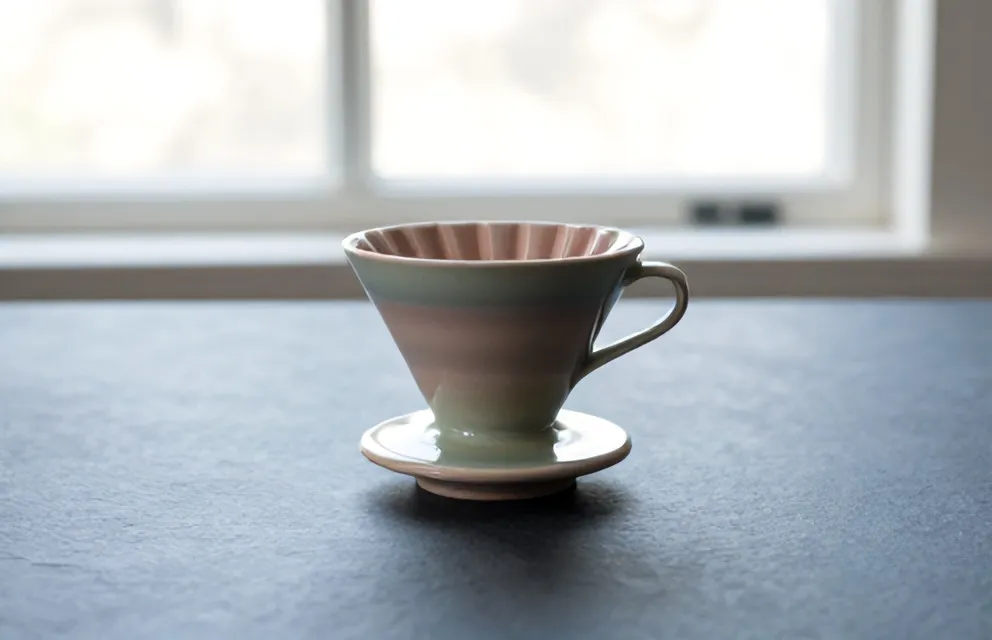 A ribbed conical stoneware dripper with glaze drips