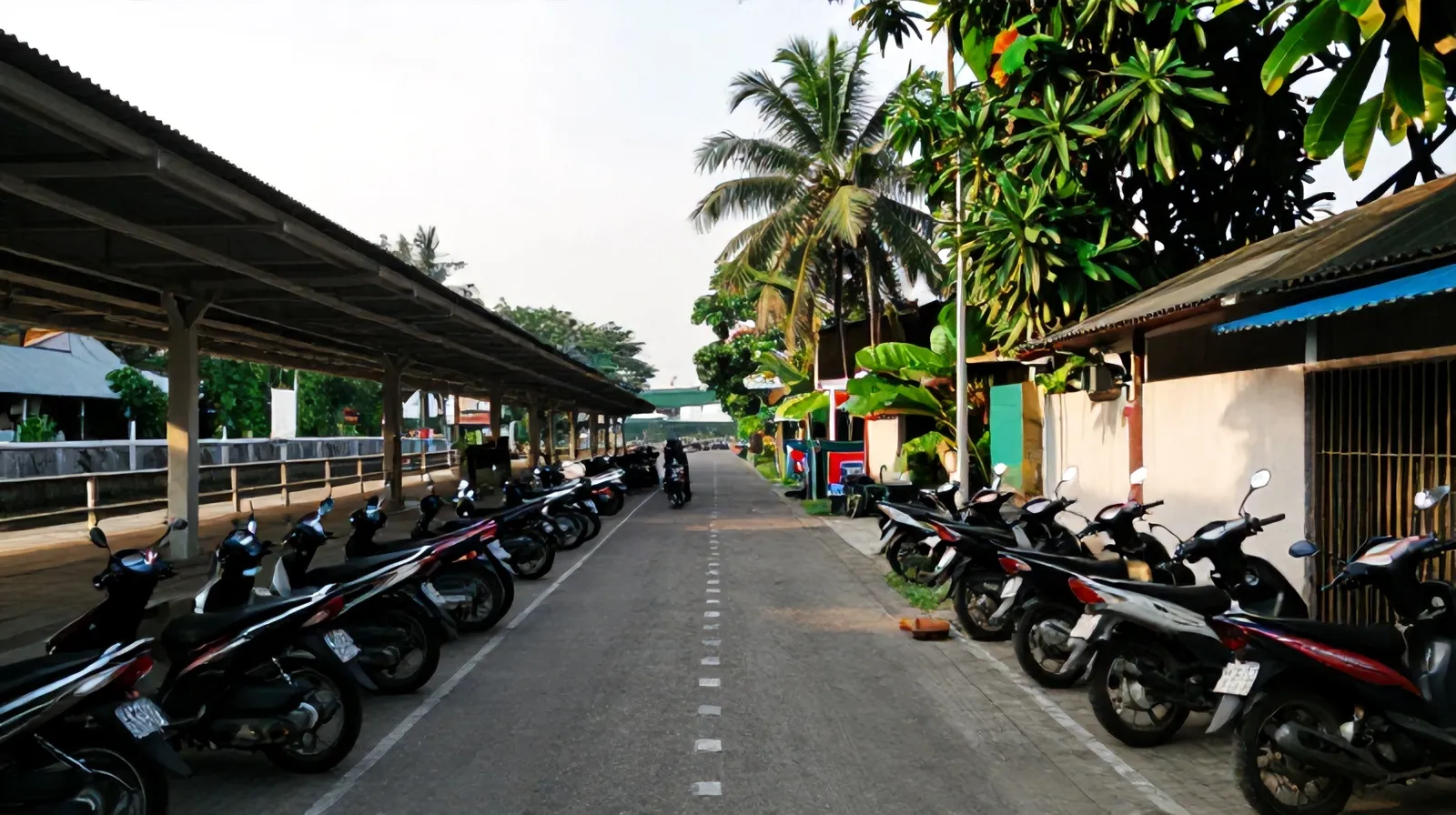 Gang berpaving di Pondok Cina menuju atap peron stasiun KRL, motor terparkir di dekat warung