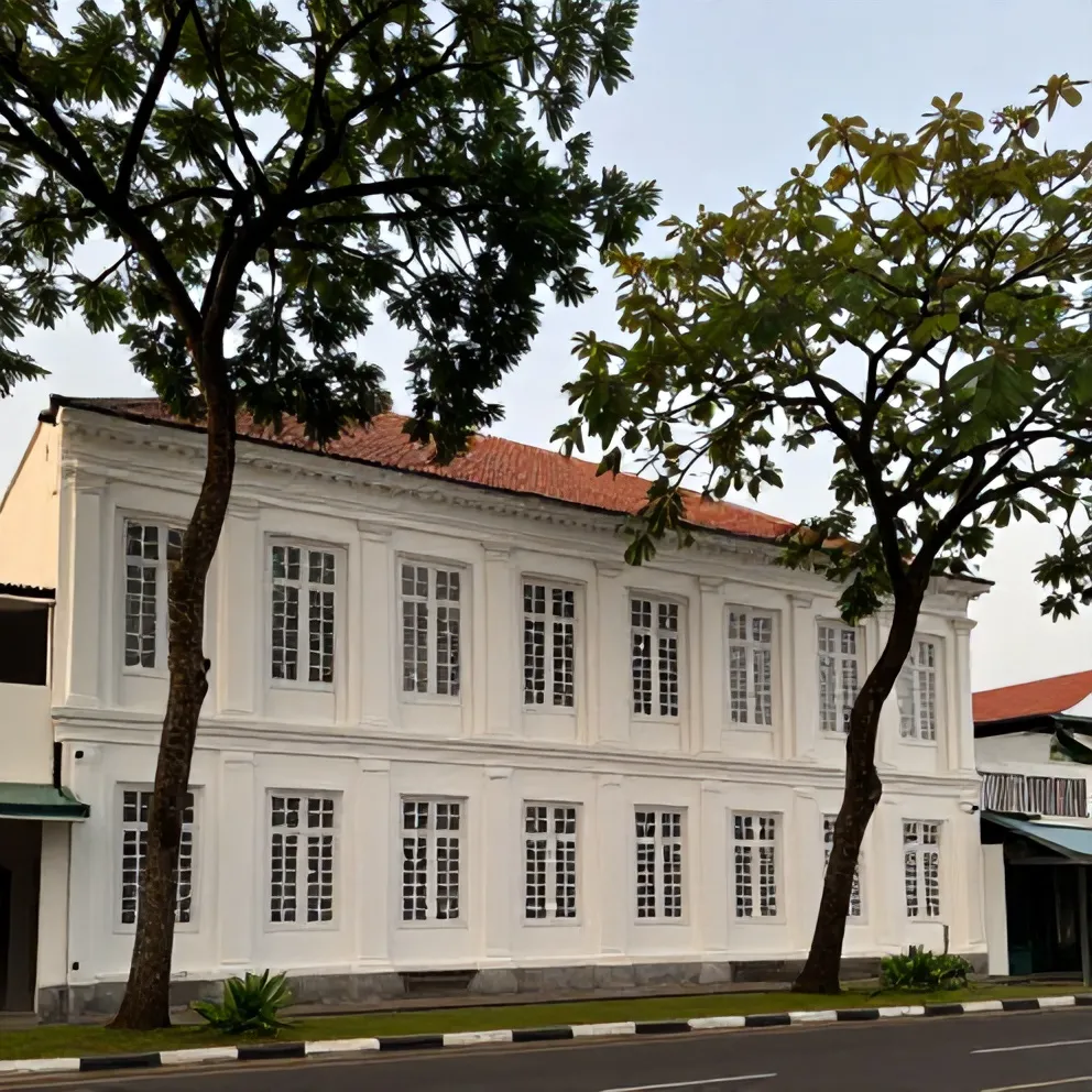Rumah kolonial berjendela tinggi di jalan besar berpohon asam, Surabaya