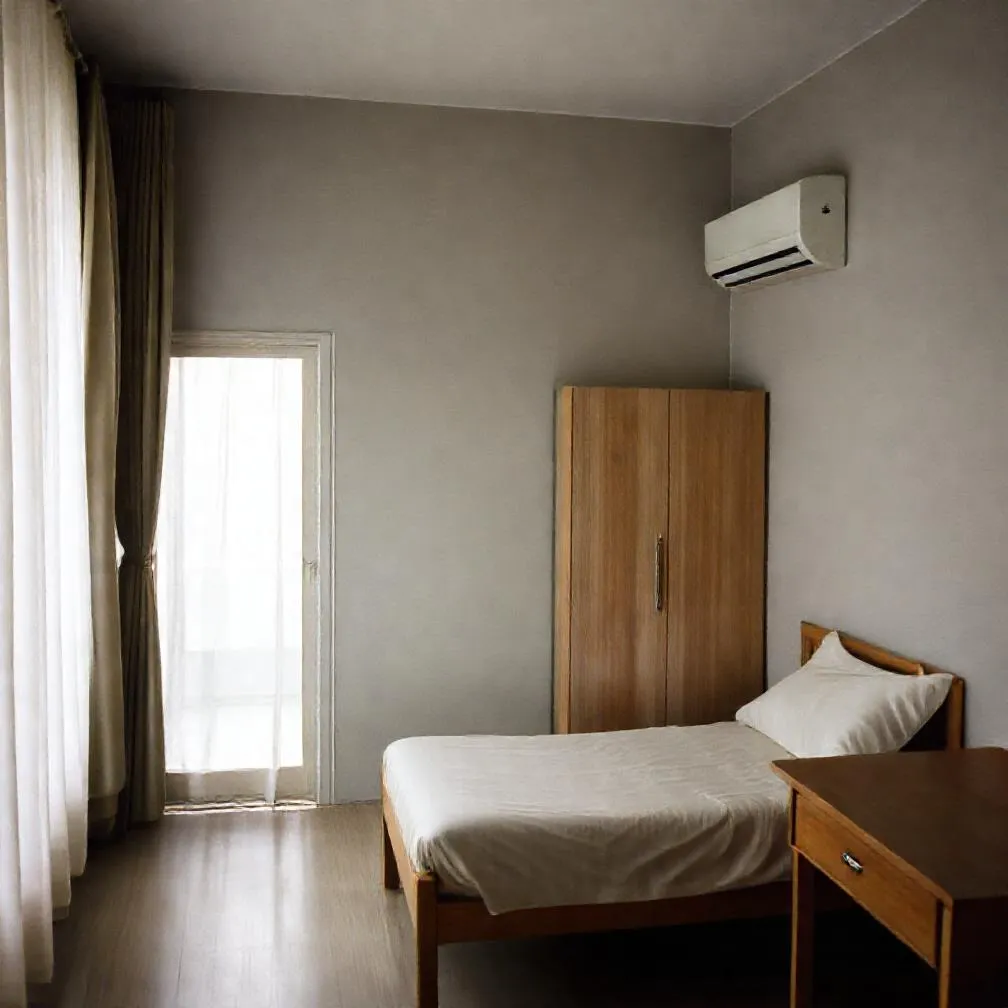 Kamar kos dengan kasur, lemari, meja belajar, AC, dan pintu kamar mandi dalam
